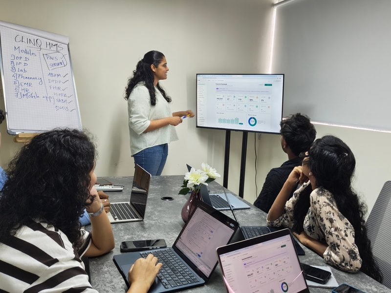 The ClinQ team walking through the executive dashboard on the meeting-room screen