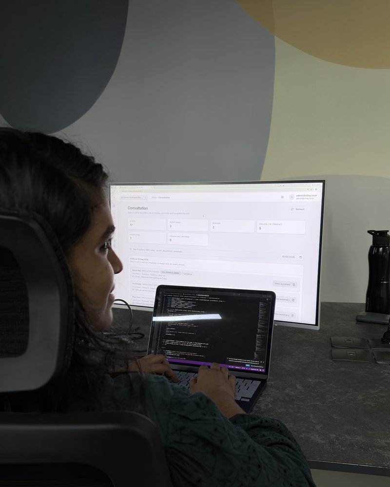 An engineer building a feature, code on the laptop and the application on the monitor