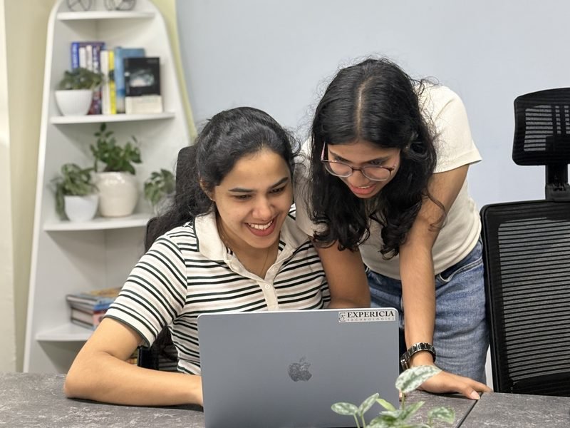 Two engineers sharing a laugh over a laptop