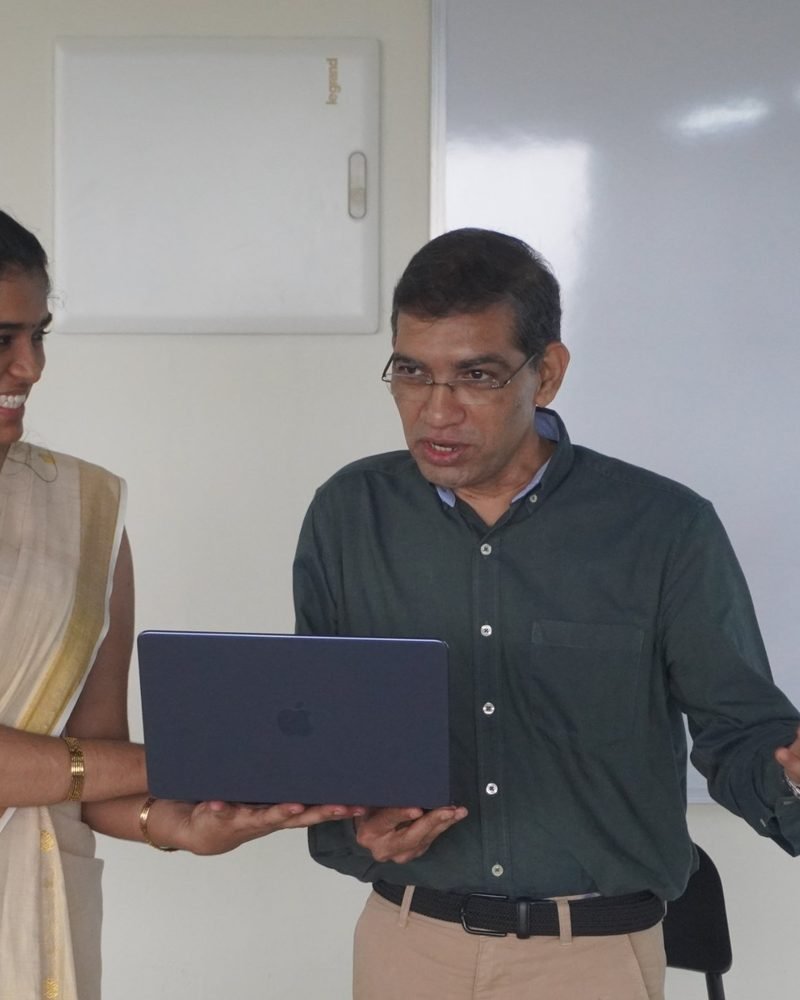 A senior architect reviewing a build with an engineer over one laptop