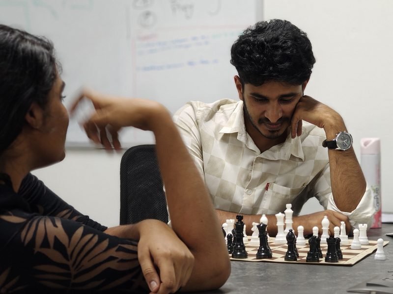 Two colleagues over a game of chess between calls at the Kochi office