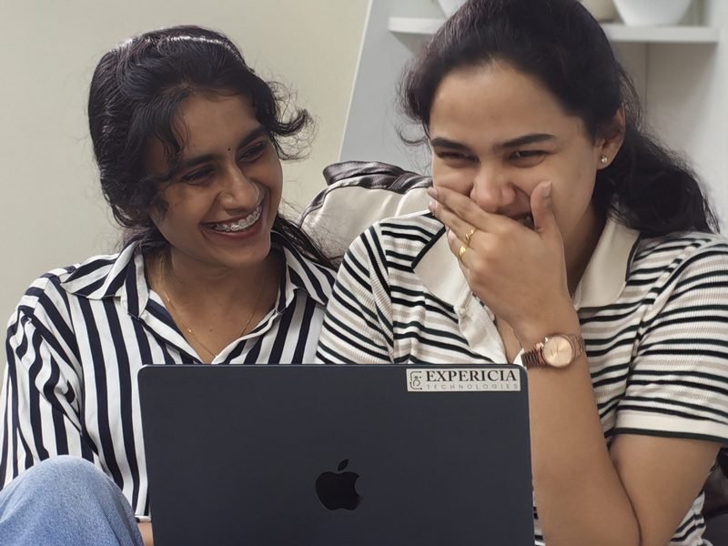 Two engineers sharing a laugh over a laptop