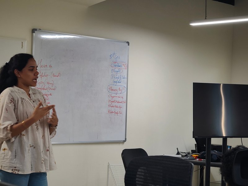 A team member walking the room through the week's priorities at the whiteboard